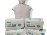 trois boîtes de masques faciaux et une tête de mannequin sur fond blanc