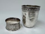 une coupe en argent à côté d'une autre coupe en argent sur une table