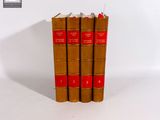 trois livres bruns posés l'un sur l'autre sur une surface blanche