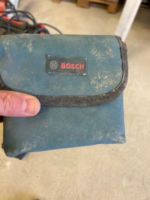a hand holding a small blue bag with a logo on it