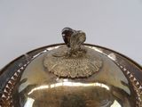 a silver plate with a bird on top of it