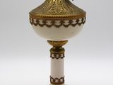 une lampe blanche et dorée posée sur une table blanche