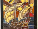 stained glass picture of a sailboat in the ocean with a sail