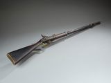 an old rifle with a wooden barrel on a white surface