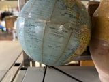 two vases sitting on a table with a globe on it