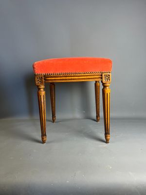 une banquette rembourrée de couleur orange, avec une structure et des pieds en bois