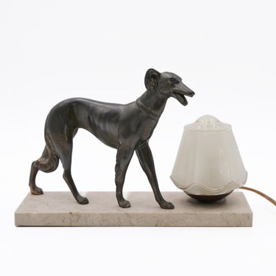 statue of a dog with a lamp on a marble base