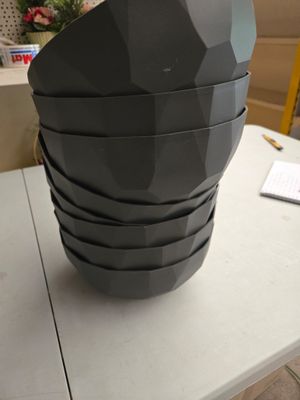 un vase noir posé sur une table blanche