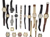 Plusieurs types de montres sont alignées sur une surface blanche