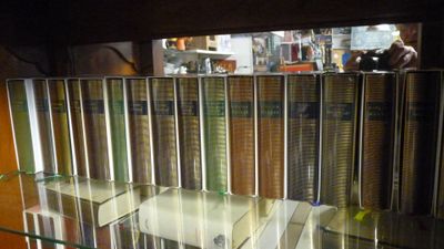 une étagère en verre sur laquelle sont posés tout un tas de livres