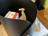 a black bucket with a bottle of cleaner and a bottle of soap in it