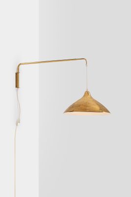 a large image of the person wall lamp in brass with a white background