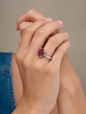the woman is wearing a ring with a ruby stone in it