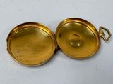 an image of a gold pocket watch on a white surface