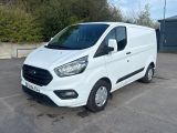 la camionnette blanche est garée sur un parking avec des arbres en arrière-plan