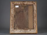 an old picture frame with a piece of wood hanging from it