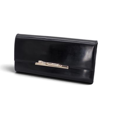 La pochette en cuir noir est posée sur une surface blanche