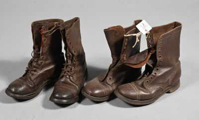 une paire de bottes en cuir marron à lacets posées sur une surface grise