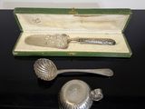 une cuillère en argent et un repose-cuillère dans une boîte