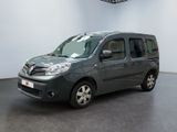 La camionnette grise est garée dans une grande pièce au sol noir.