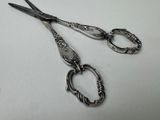 two pairs of scissors sitting on a white surface