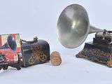 an old gramphone next to a book and a corkscrew