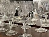 many wine glasses lined up on a wooden table