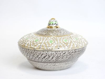 a white and green bowl with a lid on a white surface