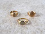 three gold rings sitting on top of a table next to each other