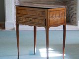 a small table with a drawer on it in front of a fireplace