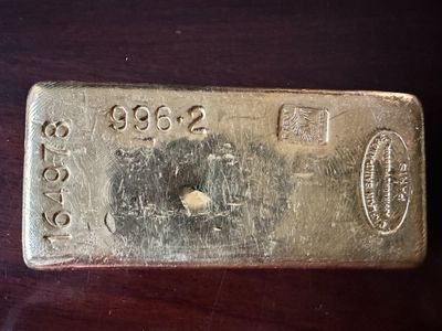 a gold bar that is sitting on top of a wooden table