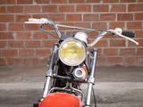 a red motorcycle parked in front of a brick wall