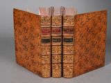 two old books sitting on top of each other on top of a table