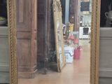 a mirror that is sitting on the floor in front of a dresser