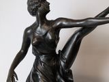 bronze statue of a woman in a dress holding a ballerina