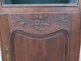 a wooden cabinet with a glass door and flowers on it