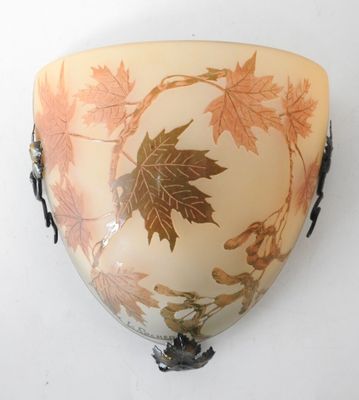 a wall mounted vase with a leaf design on it