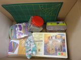 a cardboard box filled with crafting supplies and crafting supplies