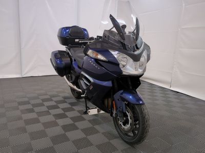 une moto qui est garée dans une pièce dont le sol est en damier