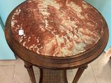 a small table with a marble top on a tile floor