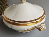 a white and gold covered dish with a gold trim