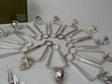 many spoons and forks arranged in a circle on a table