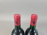 two bottles of wine sitting on top of a table next to each other