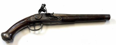 un vieux pistolet surmonté d'un homme, posé sur une surface blanche