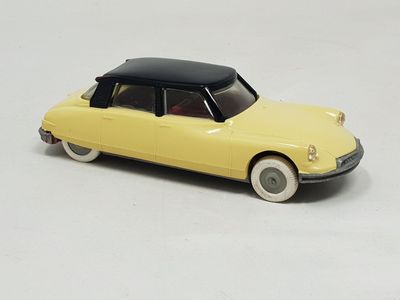 yellow toy car with black top and white wheels on a white surface