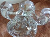 a glass candle holder sitting on the floor next to a wall