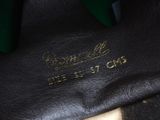 the bottom of a pair of black leather shoes with gold lettering
