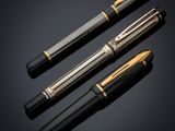 three different types of fountain pens on a black background