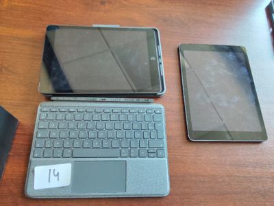 deux ordinateurs portables et une tablette posés sur une table en bois