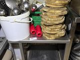 many pots and pans stacked on a table in the kitchen